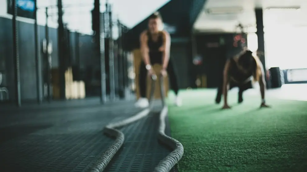 Two person inside gym exercising, illustrating movement and conditioning